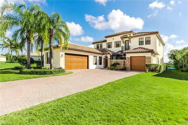 a front view of a house with a garden and trees