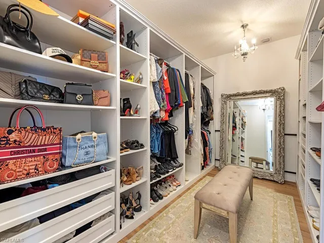 a view of walk in closet with clothes and shoes