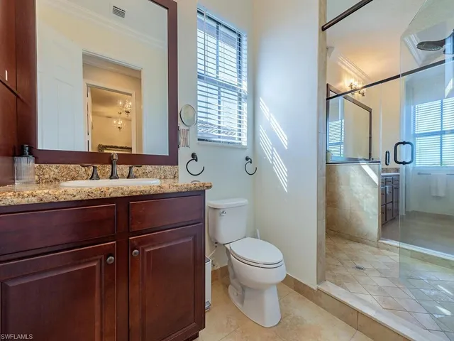 a bathroom with a granite countertop sink toilet and shower