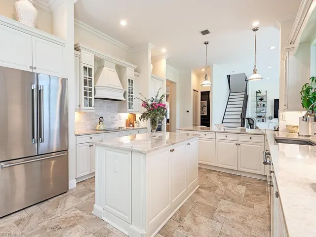 a kitchen with white cabinets and refrigerator