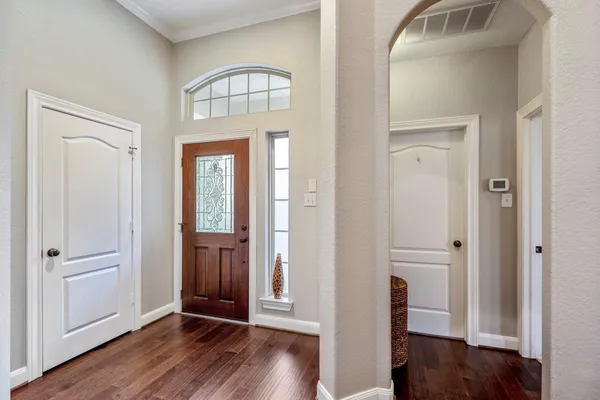 an empty room with wooden floor mirror and windows
