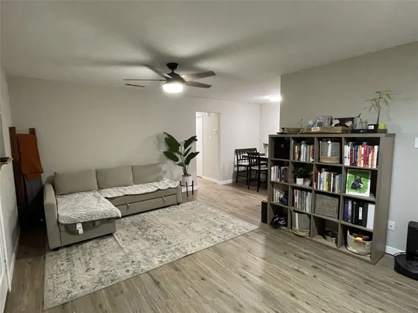 a living room with furniture and a book shelf