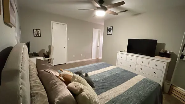 a bedroom with furniture and a flat screen tv