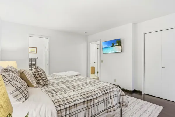 a bedroom with a bed and a wooden floor