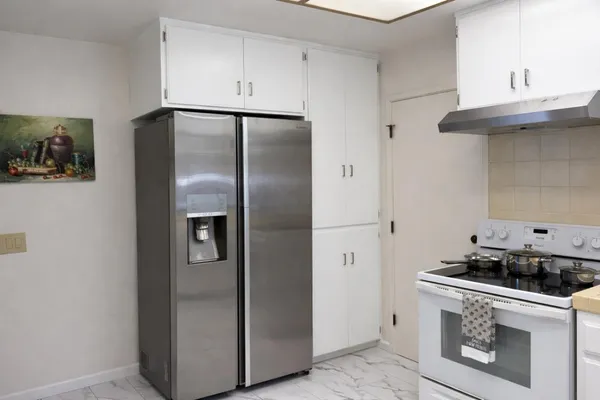 a kitchen with a refrigerator and cabinets
