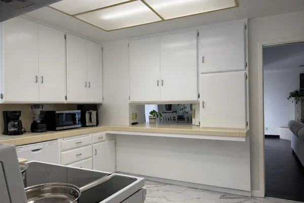 a kitchen with white cabinets and white appliances