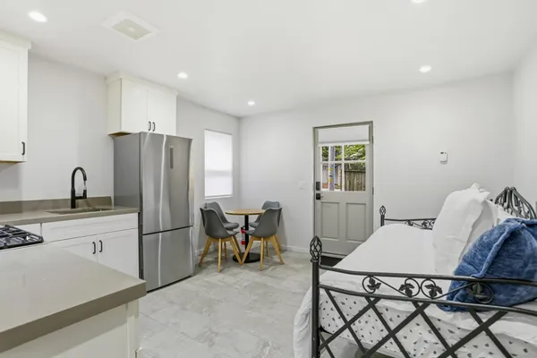 a kitchen with stainless steel appliances a refrigerator a stove a dining table and chairs