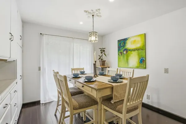 a dining room with furniture a chandelier and wooden floor