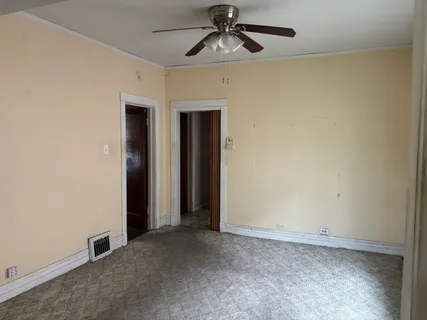 an empty room with windows and fan