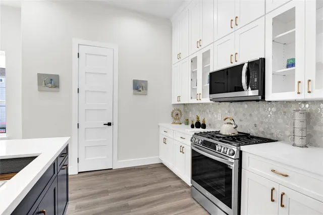a kitchen with stainless steel appliances white cabinets and stove