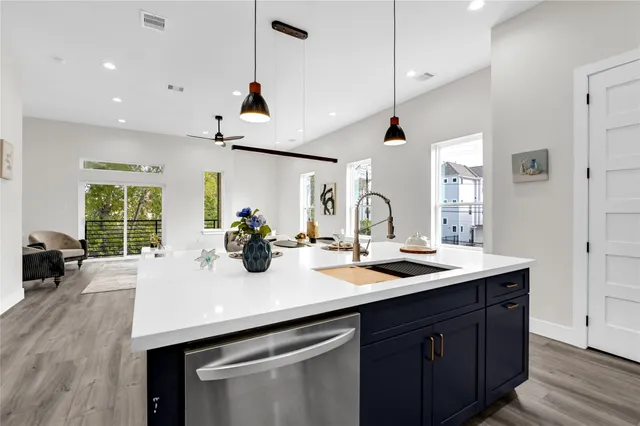 a kitchen with a sink a counter space and wooden floor