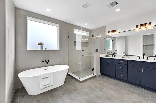 a bathroom with a tub sink and mirror