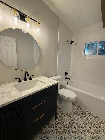 a bathroom with a double vanity sink toilet mirror and bathtub