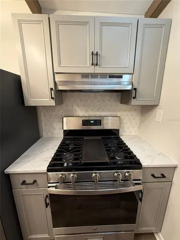 a stove top oven sitting inside of a kitchen