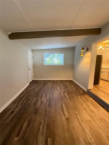a view of empty room with wooden floor