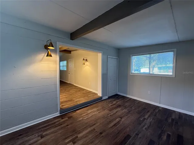 a view of empty room with wooden floor