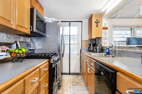 a kitchen with stainless steel appliances granite countertop sink stove top oven and cabinets