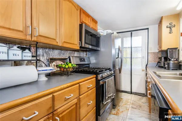a kitchen with stainless steel appliances granite countertop a stove a sink and a refrigerator