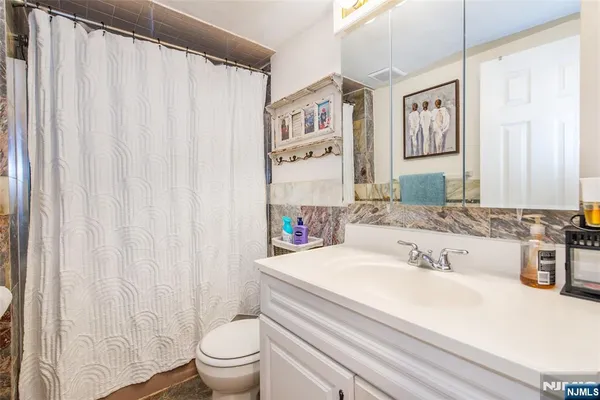 a bathroom with a sink a toilet and a mirror