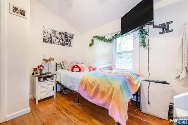 a bedroom with a bed and a flat tv screen on the dresser
