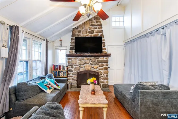 a living room with furniture a flat screen tv and a fireplace