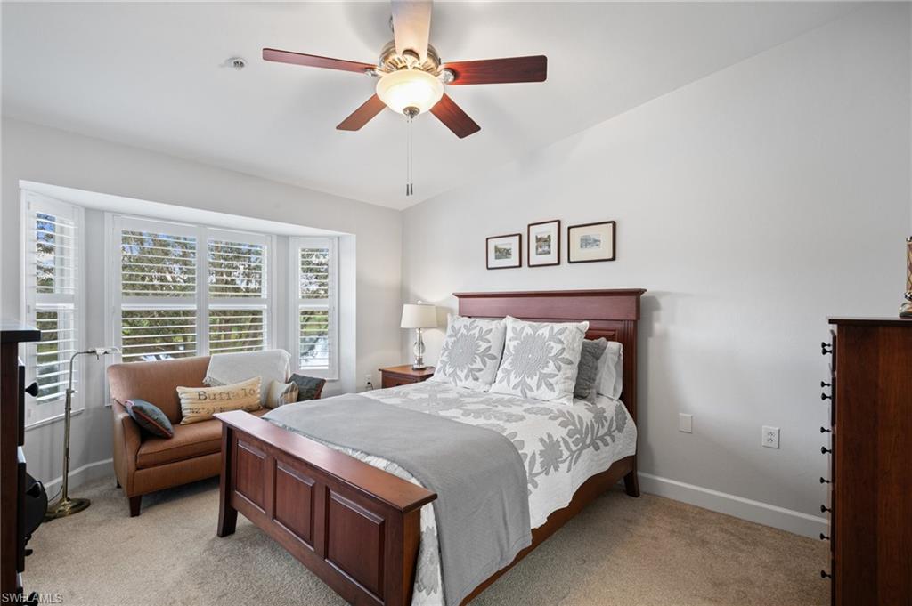 2870 Cypress Trace Circle, Unit 1723 Naples, FL 34119 - Photo 13 of 33 a bedroom with a large bed and a couch