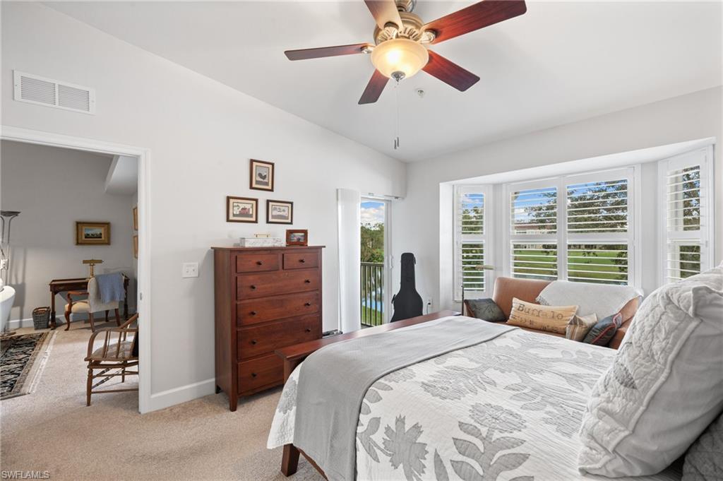 2870 Cypress Trace Circle, Unit 1723 Naples, FL 34119 - Photo 14 of 33 a bedroom with a bed a dresser and a large window