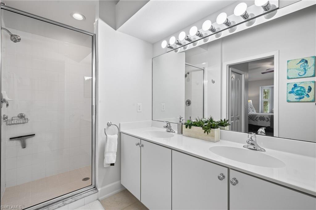 2870 Cypress Trace Circle, Unit 1723 Naples, FL 34119 - Photo 15 of 33 a bathroom with a double vanity sink and a mirror