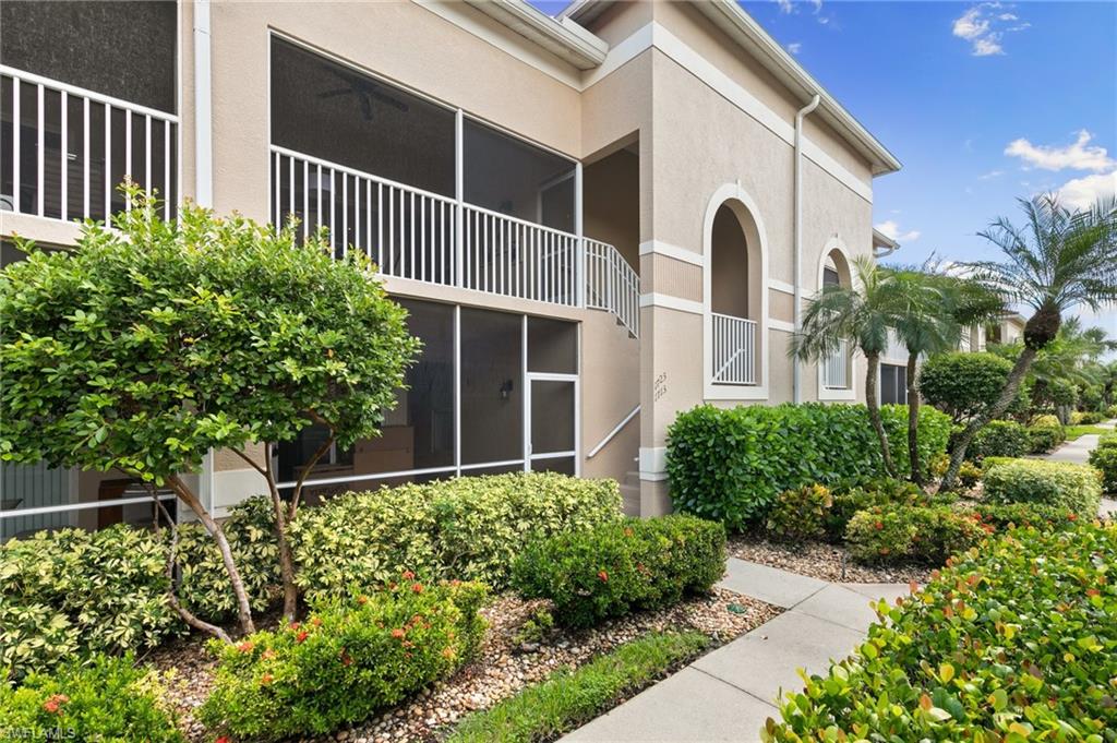 2870 Cypress Trace Circle, Unit 1723 Naples, FL 34119 - Photo 22 of 33 a view of a house with a flower garden