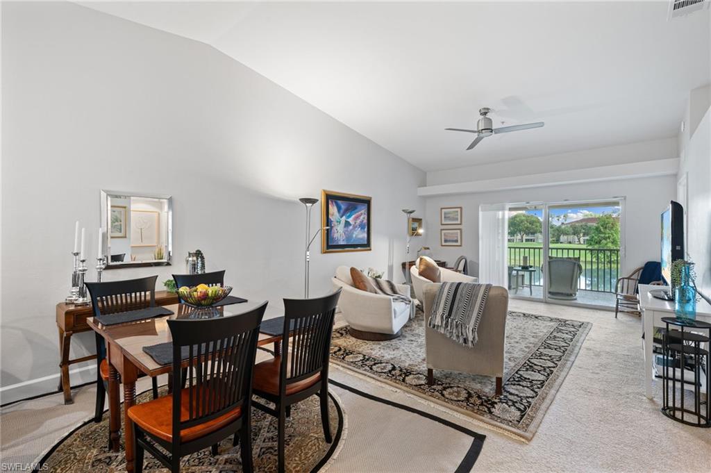 2870 Cypress Trace Circle, Unit 1723 Naples, FL 34119 - Photo 5 of 33 a living room with furniture a large window and a table