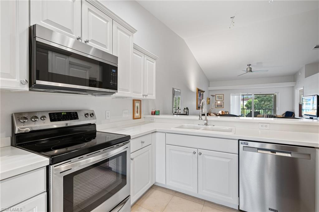 2870 Cypress Trace Circle, Unit 1723 Naples, FL 34119 - Photo 7 of 33 a kitchen with cabinets stainless steel appliances and sink