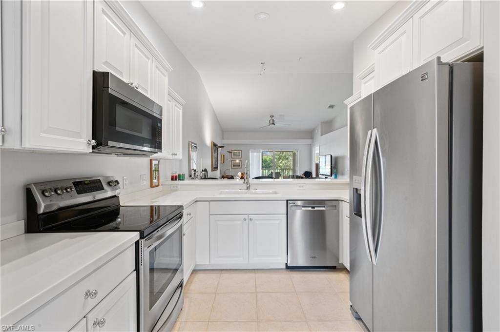 2870 Cypress Trace Circle, Unit 1723 Naples, FL 34119 - Photo 9 of 33 a kitchen with stainless steel appliances a refrigerator sink and microwave