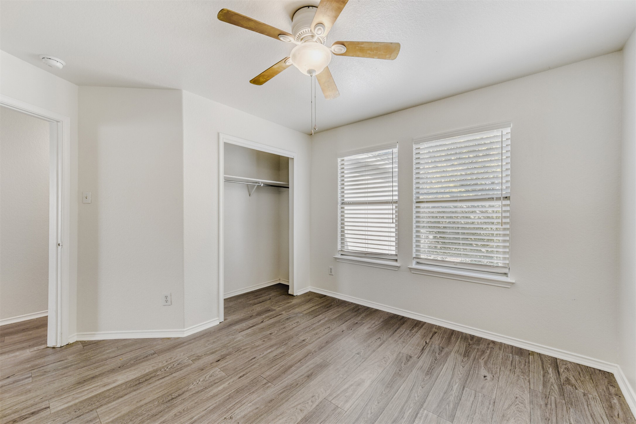 4508 Peach Grove Road Austin, TX 78744 - Photo 17 of 24 Unfurnished bedroom with a ceiling fan, light wood-style flooring, and a closet