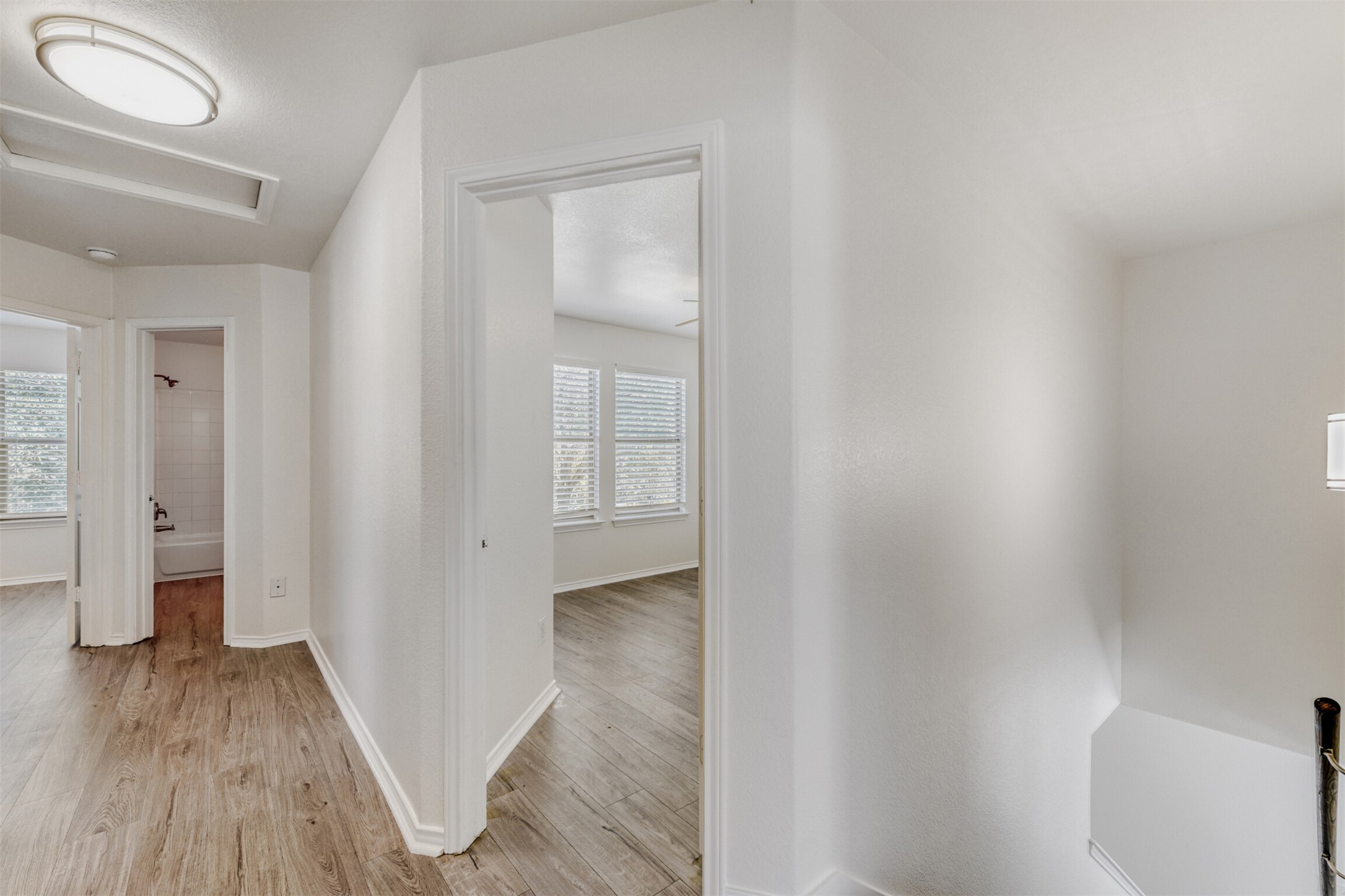 4508 Peach Grove Road Austin, TX 78744 - Photo 4 of 24 Hallway with light wood-style floors and attic access
