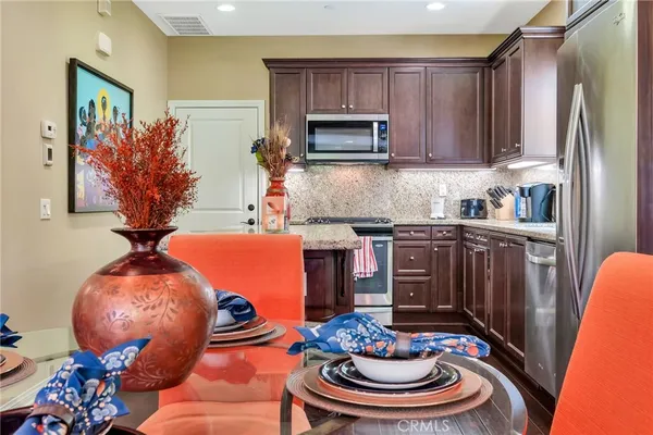 a kitchen with kitchen island granite countertop wooden floors and stainless steel appliances