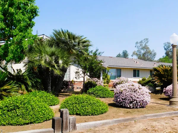 a front view of a house with a garden