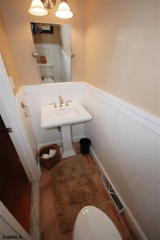 a bathroom with a sink toilet and a mirror