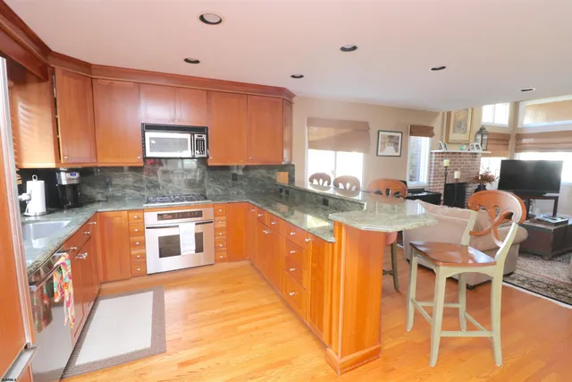 a kitchen with stainless steel appliances kitchen island granite countertop a sink and cabinets