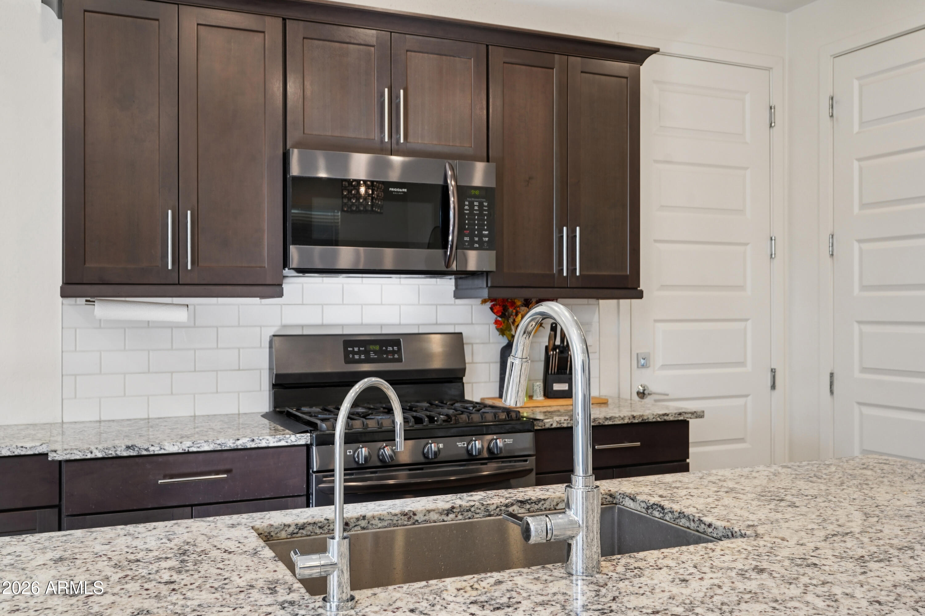 17153 North 10th Street Phoenix, AZ 85022 - Photo 15 of 48 a kitchen with granite countertop a stove a sink and a microwave