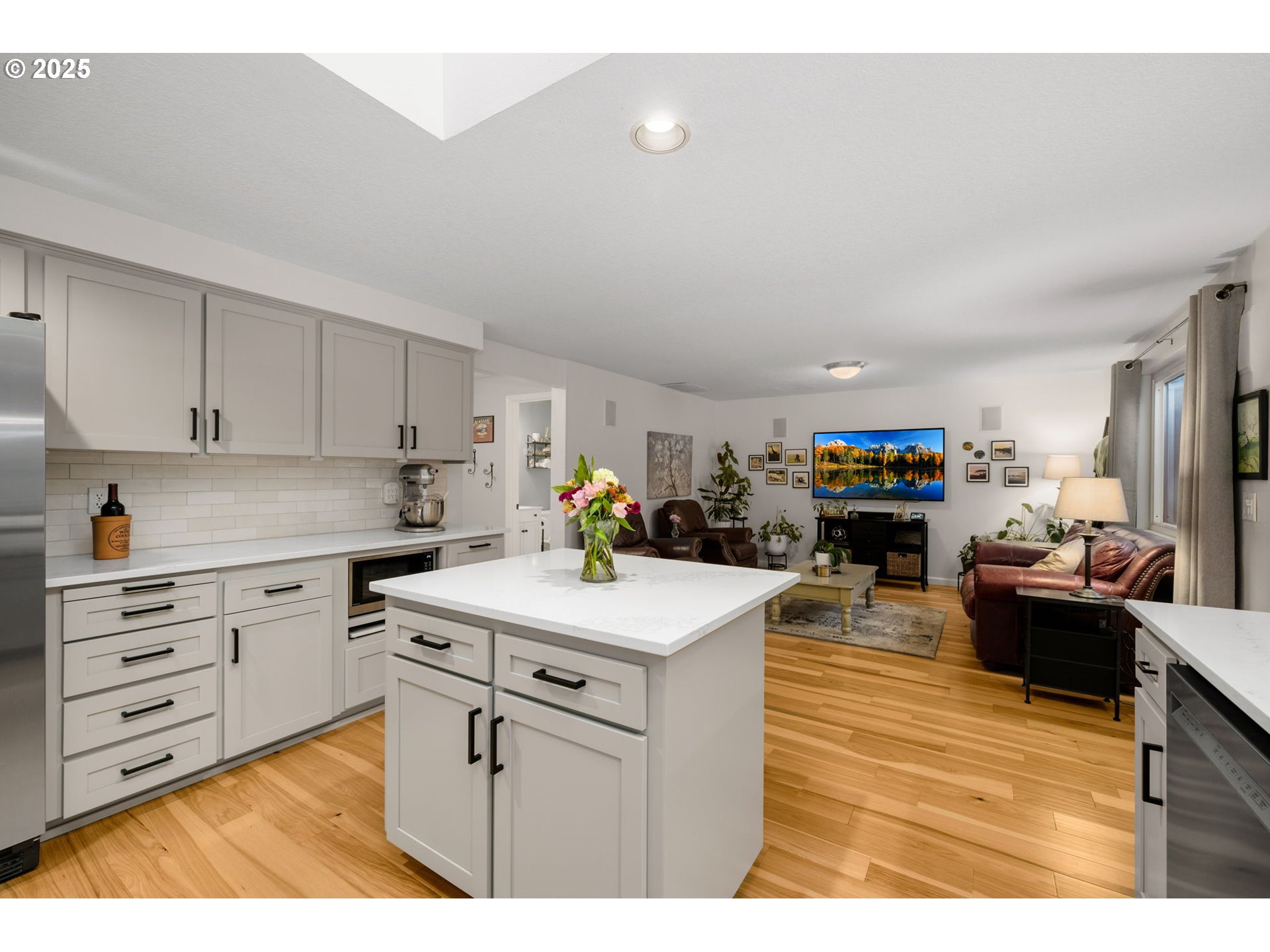 12808 Southwest Falcon Rise Drive Portland, OR 97223 - Photo 15 of 46 a kitchen with stainless steel appliances kitchen island granite countertop a sink dishwasher and white cabinets with wooden floor