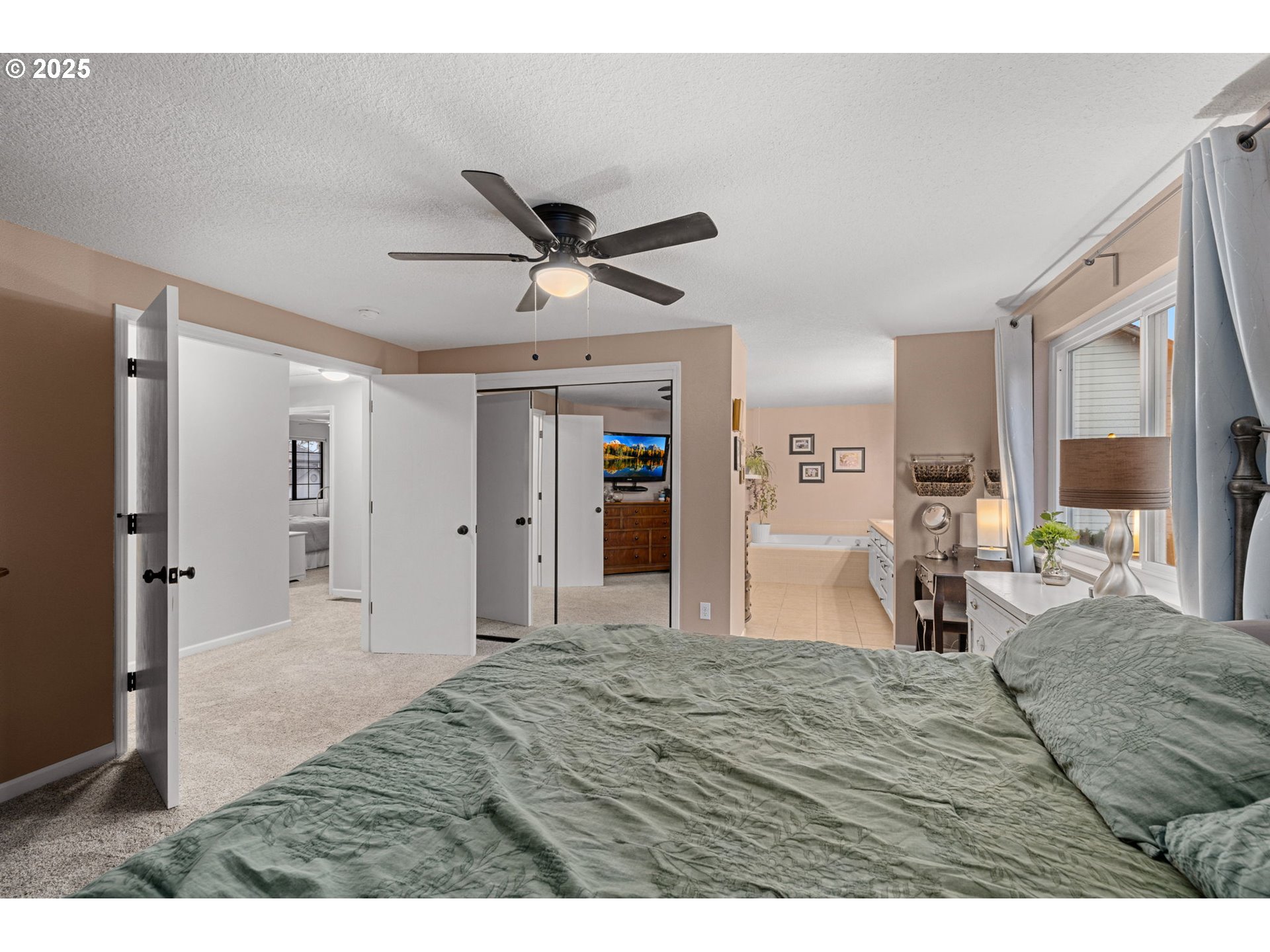 12808 Southwest Falcon Rise Drive Portland, OR 97223 - Photo 29 of 46 a bedroom with a bed and a chandelier