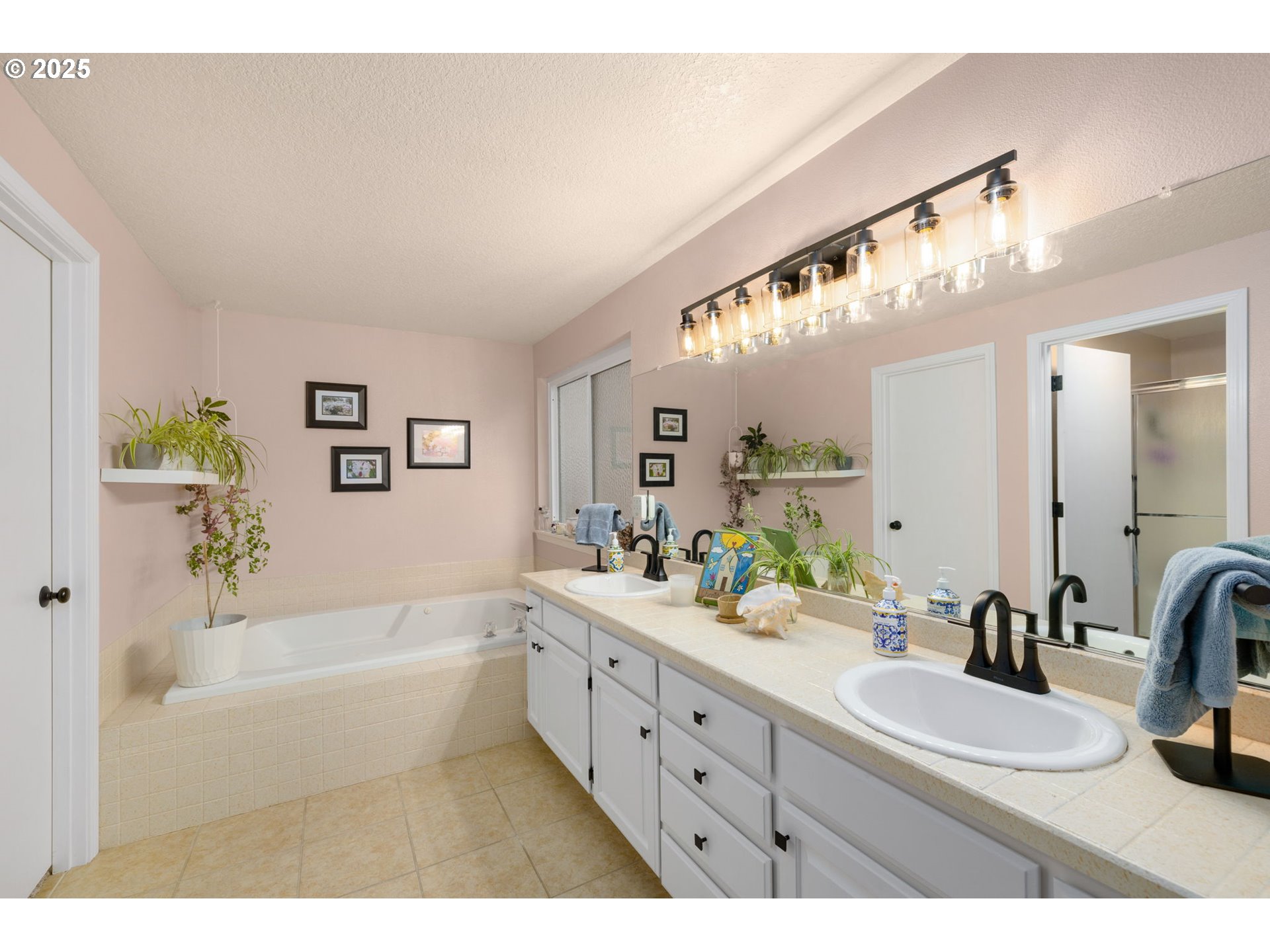 12808 Southwest Falcon Rise Drive Portland, OR 97223 - Photo 30 of 46 a bathroom with a bathtub a double vanity sink and mirror