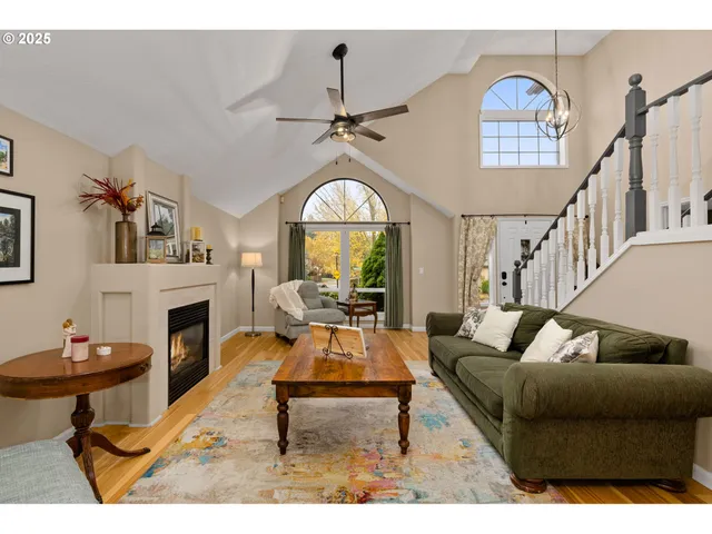 a living room with furniture a fireplace and a chandelier