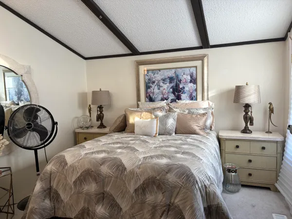 a bed room with two beds and a painting on the wall