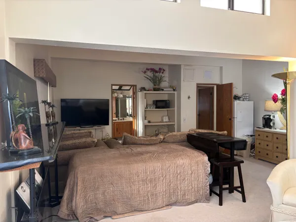 a bedroom with a bed and a flat screen tv