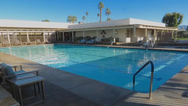 a front view of a house with swimming pool and glass windows