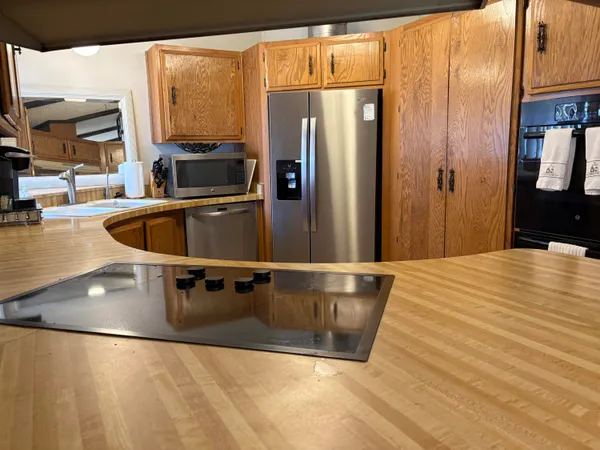 a view of a kitchen with stainless steel appliances granite countertop a refrigerator and a sink