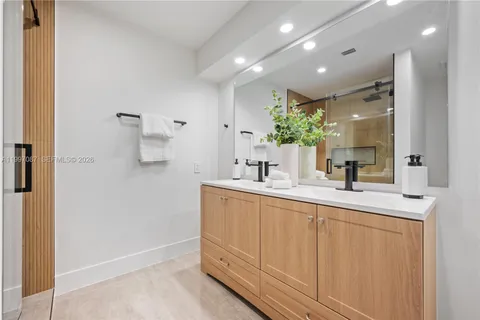 a bathroom with a sink a mirror and a shower