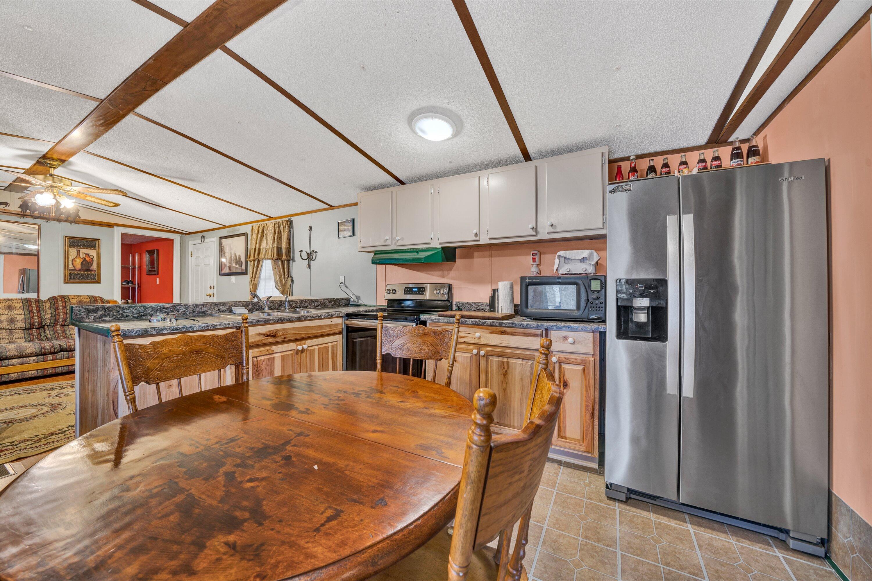 706 Telegraph Road Henry, VA 24102 - Photo 6 of 17 a kitchen with stainless steel appliances granite countertop a refrigerator a sink dishwasher a stove and white cabinets with wooden floor
