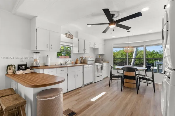 a kitchen with a table chairs stove and white cabinets